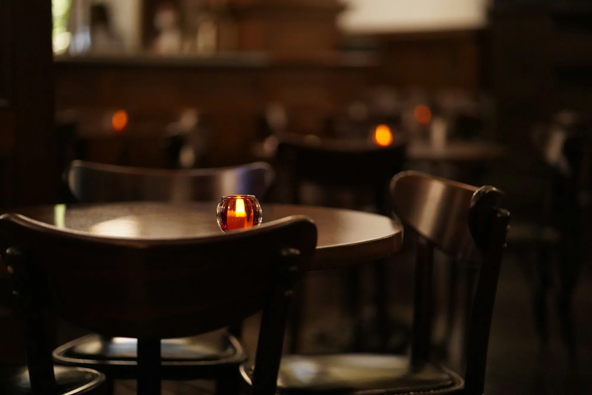 Candlelit tables in a dark dining room